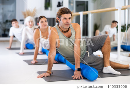 Portrait of people practicing Matsyendrasana known as Lord of Fishes Pose during group yoga training Portrait of people practicing Matsyendrasana known as Lord of Fishes Pose during group yoga training 140335906
