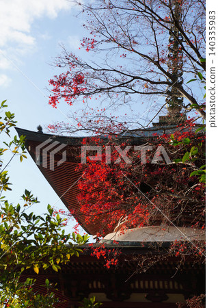 A multi-storied pagoda of a Buddhist temple in Kamitakano, northern Kyoto, against a backdrop of a blue sky. A multi-storied pagoda of a Buddhist temple in Kamitakano, northern Kyoto, against a backdrop of a blue sky. 140335983