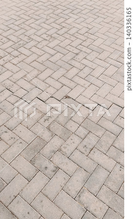 Gray interlocking brick pavement texture with damaged pavers Gray interlocking brick pavement texture with damaged pavers 140336165