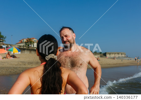 Father and Daughter Talking on Sunny Beach Shore During Summer Vacation Father and Daughter Talking on Sunny Beach Shore During Summer Vacation 140336177