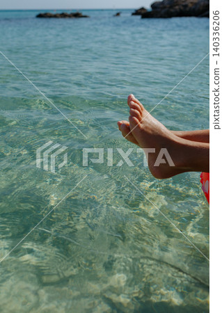 close up of Child feet Relaxing on Inflatable Ring in Crystal Clear Sea Water close up of Child feet Relaxing on Inflatable Ring in Crystal Clear Sea Water 140336206