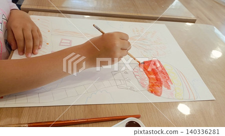 Child Painting with Watercolors - Kids Art Activity Drawing Colorful Picture on Paper at Wooden Table 140336281