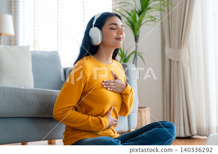 Happy young Asian woman practicing yoga and meditation at home Happy young Asian woman practicing yoga and meditation at home 140336292