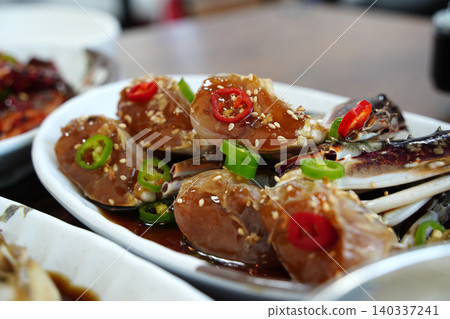 Delicious Korean seafood dish, savory soy sauce marinated crab on a plate Delicious Korean seafood dish, savory soy sauce marinated crab on a plate 140337241