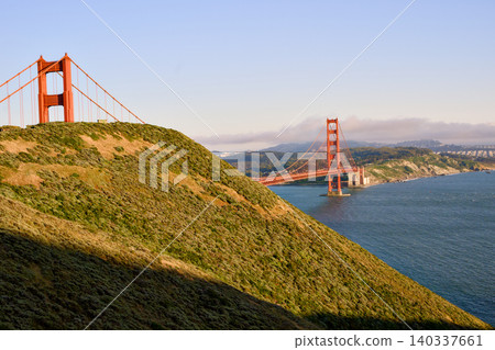 Sunlit Marin Headlands framing Golden Gate Bridge over blue bay Sunlit Marin Headlands framing Golden Gate Bridge over blue bay 140337661