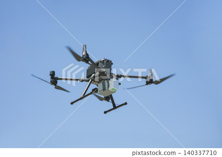 Images of industrial drones flying in the blue sky for aerial photography and surveying technology. Images of industrial drones flying in the blue sky for aerial photography and surveying technology. 140337710