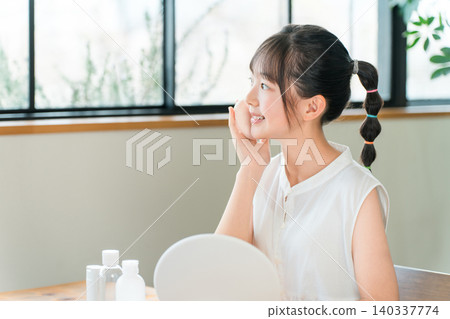 Children, girls, elementary school students, junior high school students putting on makeup while looking in the mirror 140337774