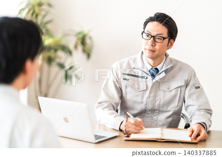 A male engineer in work clothes and a client having a meeting. 140337885