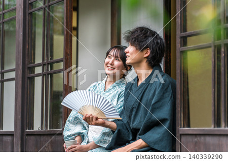 A couple in yukata enjoying the evening breeze on the veranda of a traditional Japanese house. 140339290