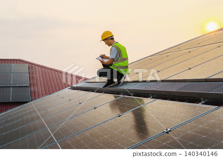 Solar technician inspects panels with notebook Solar technician inspects panels with notebook 140340146