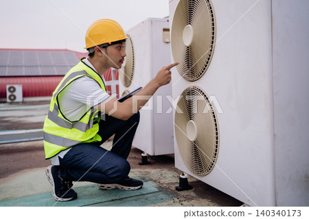 Technician inspects outdoor cooling unit with focused attention Technician inspects outdoor cooling unit with focused attention 140340173