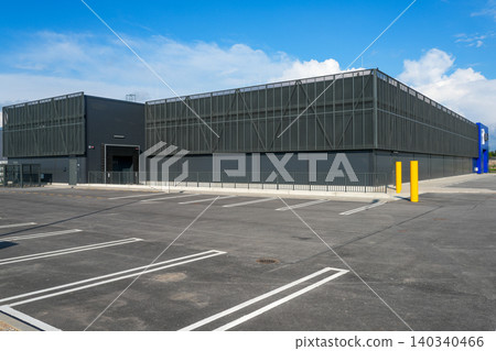 Modern logistics warehouse building with empty parking lot and industrial architecture exterior view Modern logistics warehouse building with empty parking lot and industrial architecture exterior view 140340466