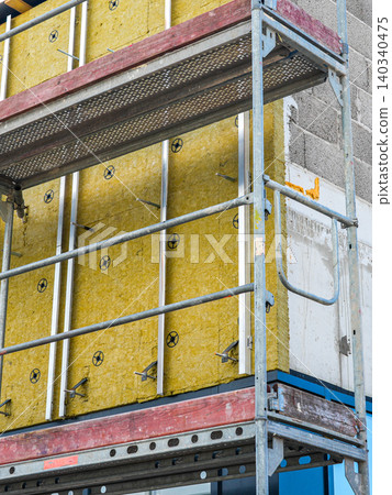 Close-up of mineral wool facade insulation and scaffolding on commercial building construction site Close-up of mineral wool facade insulation and scaffolding on commercial building construction site 140340475