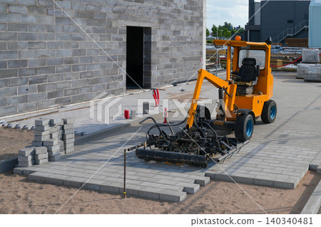 Mechanical paver machine installing concrete paving stones at commercial construction project site Mechanical paver machine installing concrete paving stones at commercial construction project site 140340481