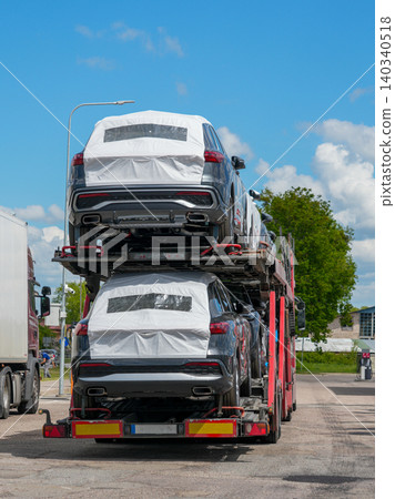 Rear view of new SUVs on car carrier truck ready for automotive logistics and dealer delivery Rear view of new SUVs on car carrier truck ready for automotive logistics and dealer delivery 140340518