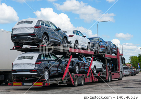 New SUVs transported on car carrier truck during vehicle logistics and automotive distribution New SUVs transported on car carrier truck during vehicle logistics and automotive distribution 140340519