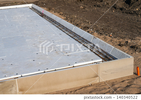 Insulated foundation edge beam with steel reinforcement prepared for concrete slab construction work 140340522