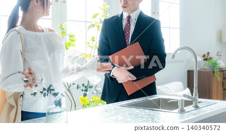 一個商人帶一位獨居女士看房子的場景。 一個商人帶一位獨居女士看房子的場景。 140340572
