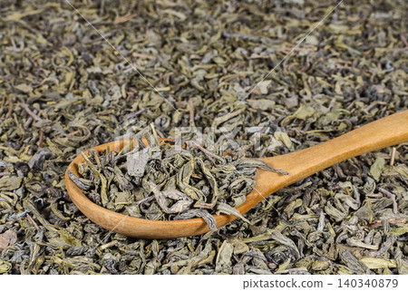 Heap of green tea in the wooden spoon 140340879