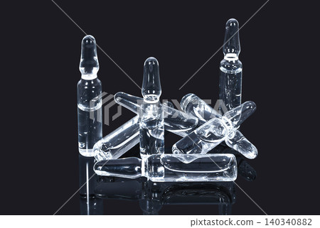 Heap of medical ampules with transparent vacccine on a dark background Heap of medical ampules with transparent vacccine on a dark background 140340882
