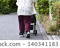 A cityscape of Yokohama, Japan: An elderly woman returning from shopping, with various items including vegetables in her four-wheeled shopping cart... (Yokohama City) 140341183