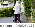 A cityscape of Yokohama, Japan: An elderly woman returning from shopping, with various items including vegetables in her four-wheeled shopping cart... (Yokohama City) 140341184