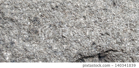 Natural grey granite texture that shows the details of mineral grains and distinctive crystal patterns on the stone surface. Natural grey granite texture that shows the details of mineral grains and distinctive crystal patterns on the stone surface. 140341839