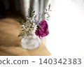 Sunlight streaming in through the window, reddish-purple ranunculus on the table 140342383