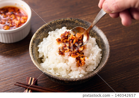 將辣椒油淋在米飯上。 將辣椒油淋在米飯上。 140342657