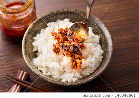將辣椒油淋在米飯上。 將辣椒油淋在米飯上。 140342661