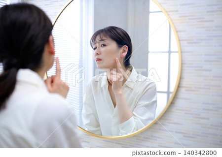 Senior woman looking in the mirror and worrying Senior woman looking in the mirror and worrying 140342800