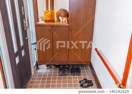 Japan: Taking off shoes at the entrance of a house; safety in old age. Japan: Taking off shoes at the entrance of a house; safety in old age. 140342829