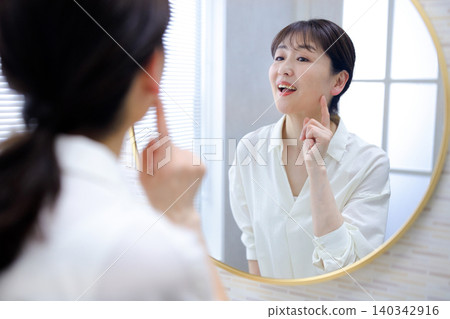 Senior woman smiling in the mirror Senior woman smiling in the mirror 140342916