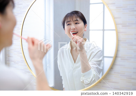 A senior woman brushing her teeth A senior woman brushing her teeth 140342919