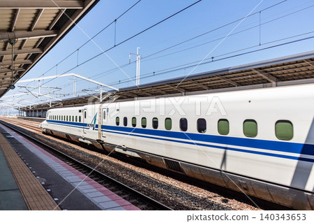 一列新幹線N700系列列車在藍天下駛過月台。 一列新幹線N700系列列車在藍天下駛過月台。 140343653