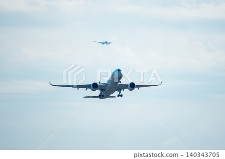 A passenger plane taking off and a passenger plane landing 140343705