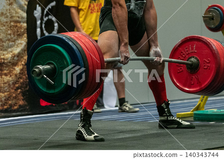 Man powerlifter with record weight of barbell Man powerlifter with record weight of barbell 140343744