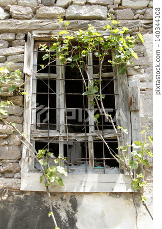 broken window of an old stone house 140344108