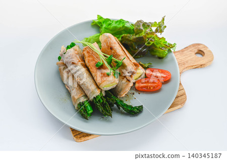 Sautéed zucchini and asparagus wrapped in meat, seasoned with salt and pepper. Sautéed zucchini and asparagus wrapped in meat, seasoned with salt and pepper. 140345187
