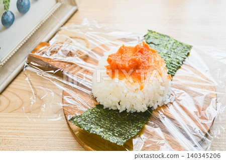Homemade spicy cod roe rice ball and seaweed made on plastic wrap Homemade spicy cod roe rice ball and seaweed made on plastic wrap 140345206
