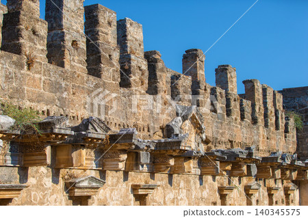 Part of the stone wall of the ancient amphitheater with architectural elements. Part of the stone wall of the ancient amphitheater with architectural elements. 140345575