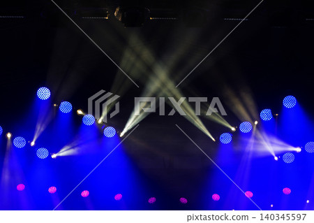 A stage with multiple blue and red lights is lit up. The blue lights are positioned on the left side of the stage, while the red lights are on the right side A stage with multiple blue and red lights is lit up. The blue lights are positioned on the left side of the stage, while the red lights are on the right side 140345597