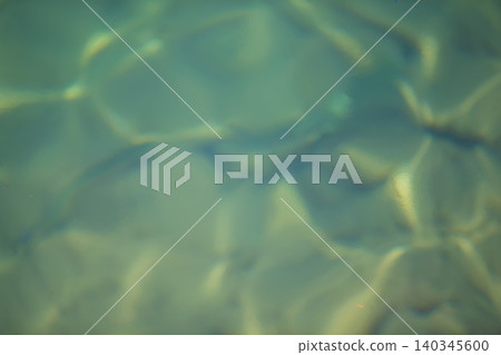 A blurry image of water with a greenish tint. The water appears to be rippling and has a hazy quality A blurry image of water with a greenish tint. The water appears to be rippling and has a hazy quality 140345600