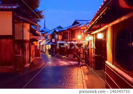 Before dawn in winter, Sannenzaka is lightly dusted with snow. The five-story pagoda stands undisturbed by the light of the streetlights and the cobblestones on the left curve. 140345733