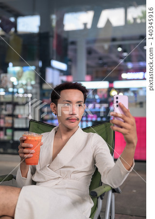 Thai Non-Binary Gay Man Vlogging with Iced Tea Vertical Portrait Thai Non-Binary Gay Man Vlogging with Iced Tea Vertical Portrait 140345916