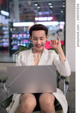 Thai Non-Binary Gay Man Video Calling on Laptop Outdoors 140345938