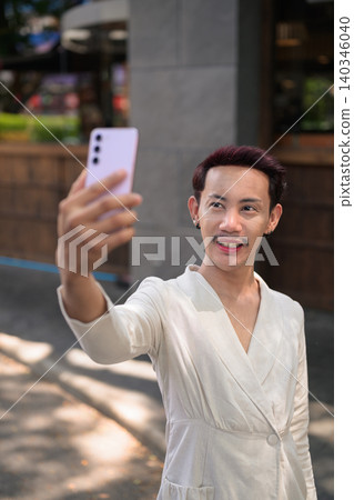 Vertical Portrait of Thai Non-Binary Gay Man Taking Selfie Outside Cafe Vertical Portrait of Thai Non-Binary Gay Man Taking Selfie Outside Cafe 140346040