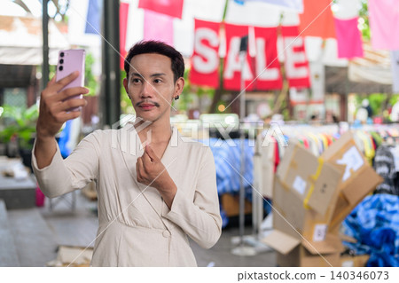Thai Non-Binary Gay Man Making Finger Heart Selfie at Market Sale Thai Non-Binary Gay Man Making Finger Heart Selfie at Market Sale 140346073
