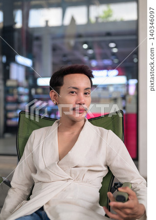 Thai Non-Binary Gay Man Sitting in Folding Chair Vertical Portrait Thai Non-Binary Gay Man Sitting in Folding Chair Vertical Portrait 140346097