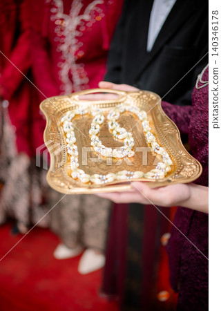 Traditional Indonesian wedding ceremony, jasmine flower garland on a gold tray. Traditional Indonesian wedding ceremony, jasmine flower garland on a gold tray. 140346178